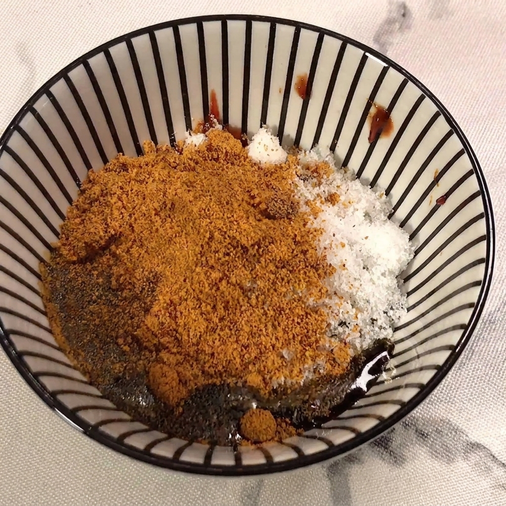 Salsa di soia chiara versata nel composto di pasta di peperoncino, zucchero e condimento.