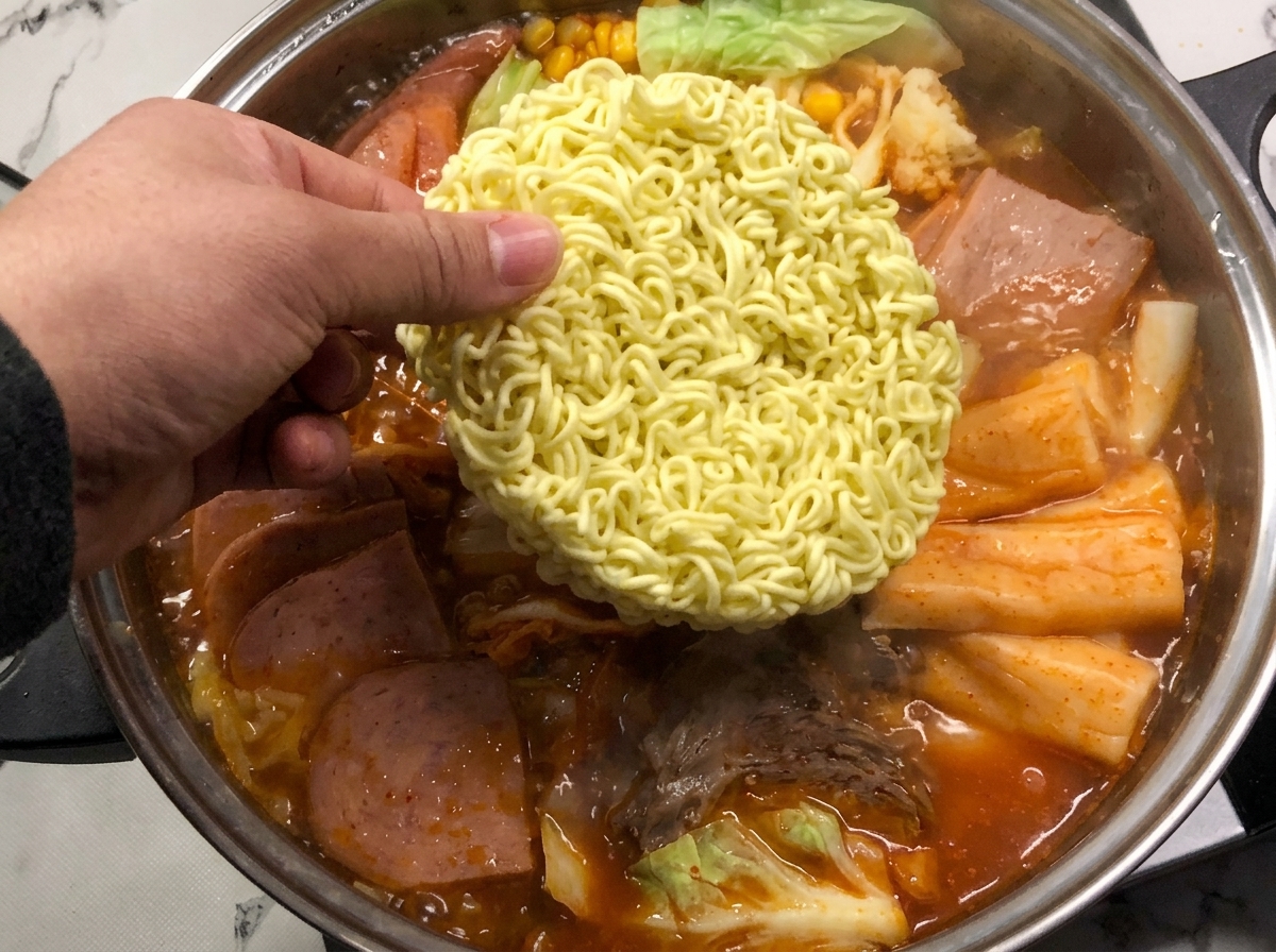 Un panetto di noodles istantanei immerso nel brodo rosso bollente.