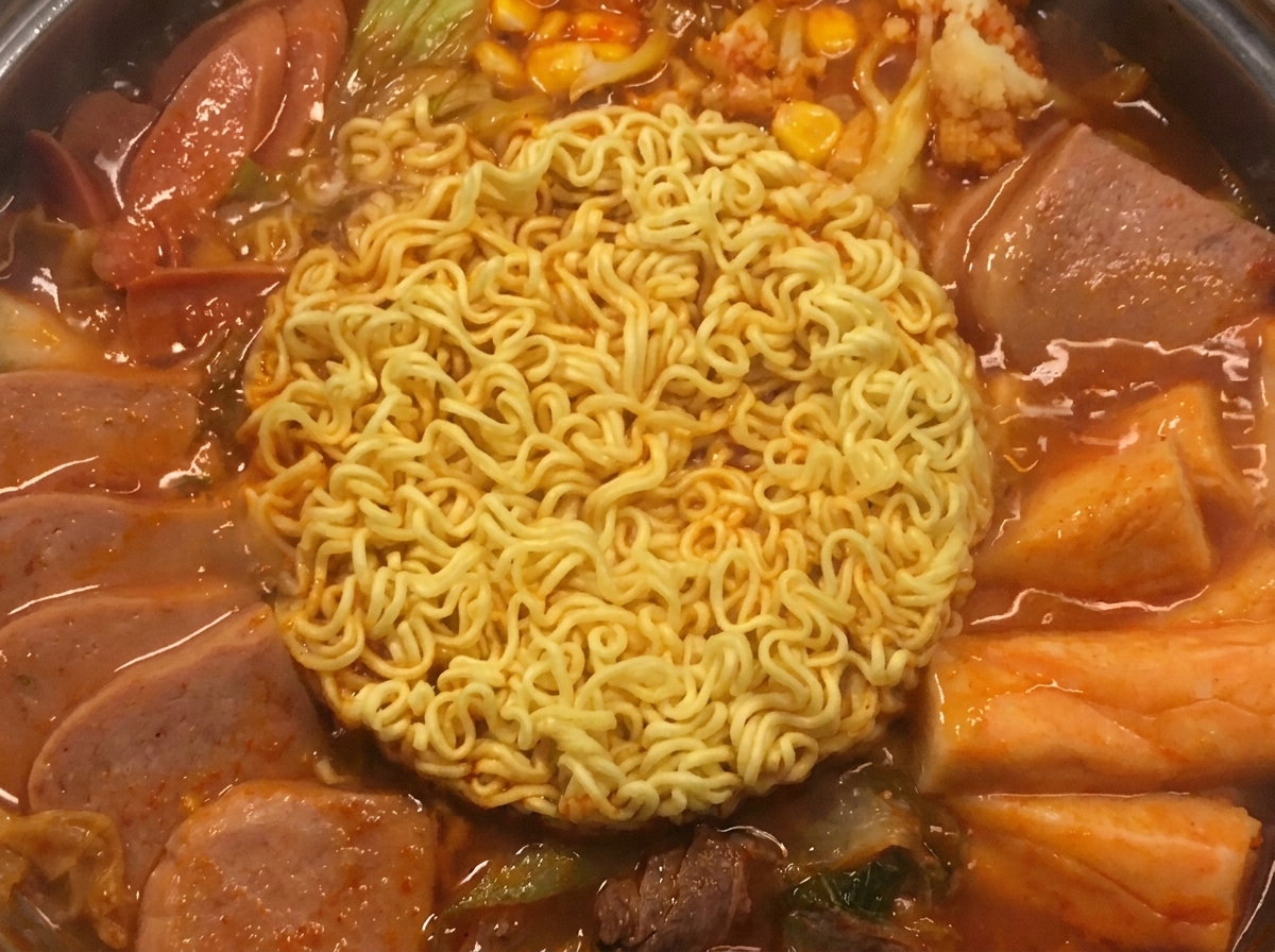 Due fette di formaggio giallo che si sciolgono lentamente sopra i noodles.