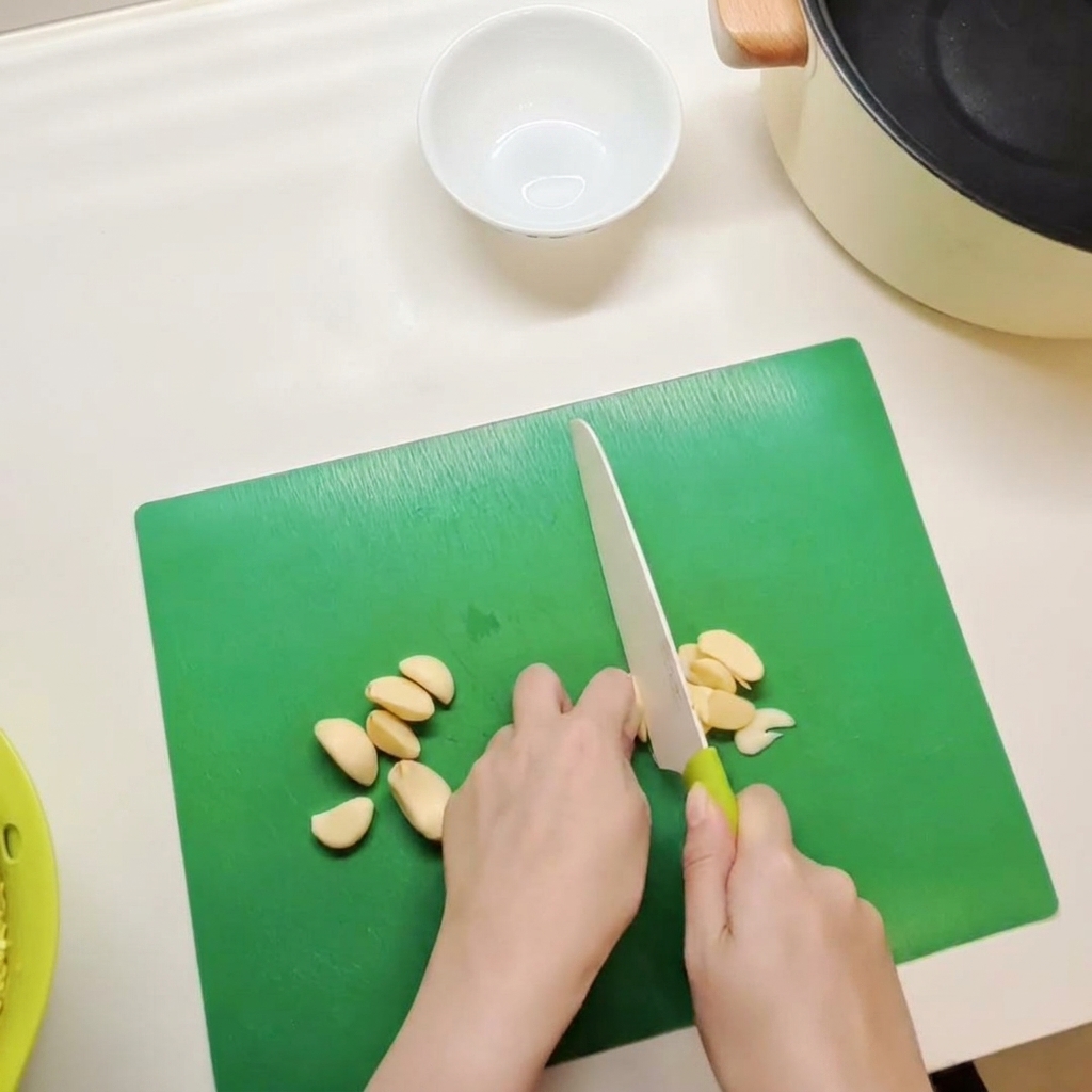 Una piccola ciotola bianca contenente una miscela di pasta di peperoncino rosso, salsa di soia e condimenti mentre viene mescolata.