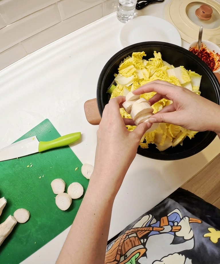 Tofu sodo affettato ordinatamente a pezzi rettangolari su un tagliere, pronto per essere aggiunto allo stufato.