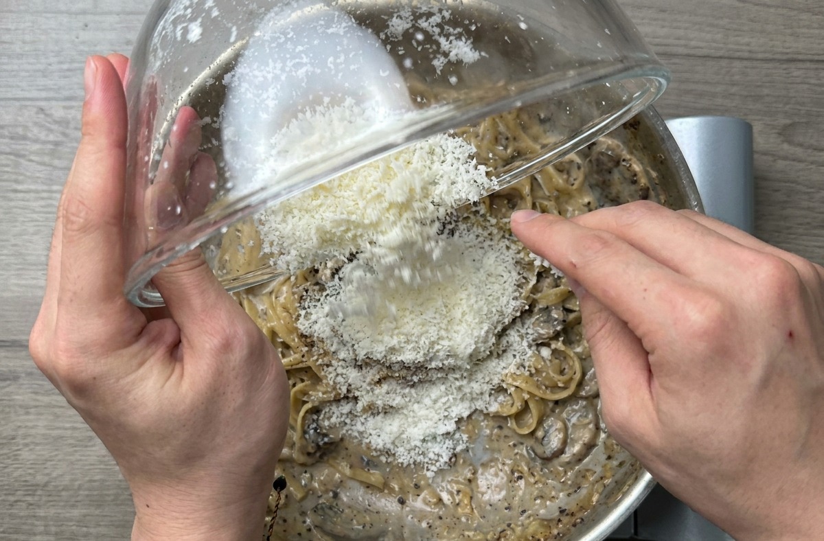 Primo piano degli spaghetti mantecati in padella per ottenere una crema lucida.