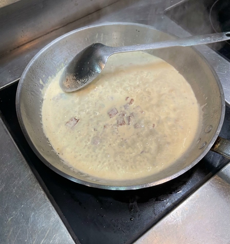 Sale e pepe nero spolverati nella padella con panna e bacon.