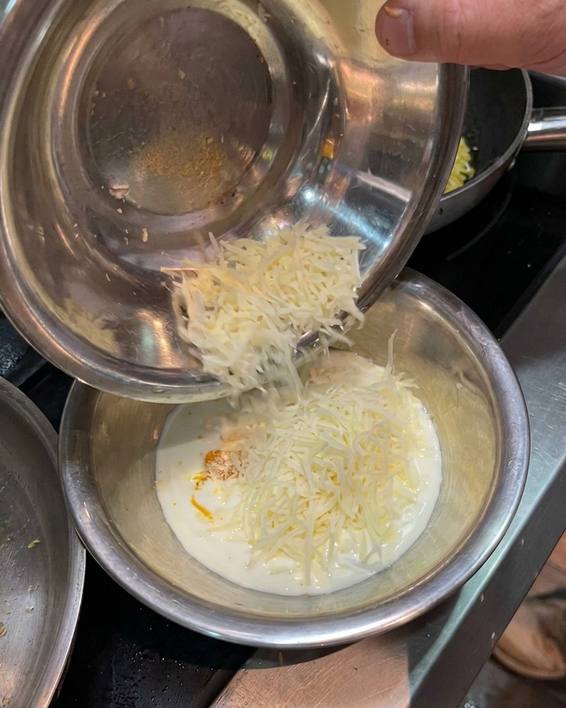 Parmigiano grattugiato aggiunto al composto di tuorlo e panna.