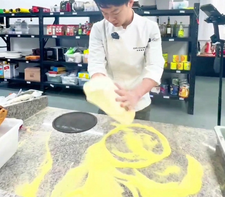 Uno chef che solleva e allarga limpasto della pizza in una cucina professionale.