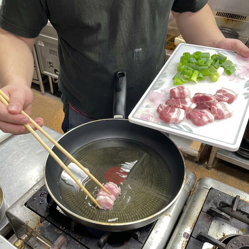 Fette di pancetta cruda disposte in una padella con olio.