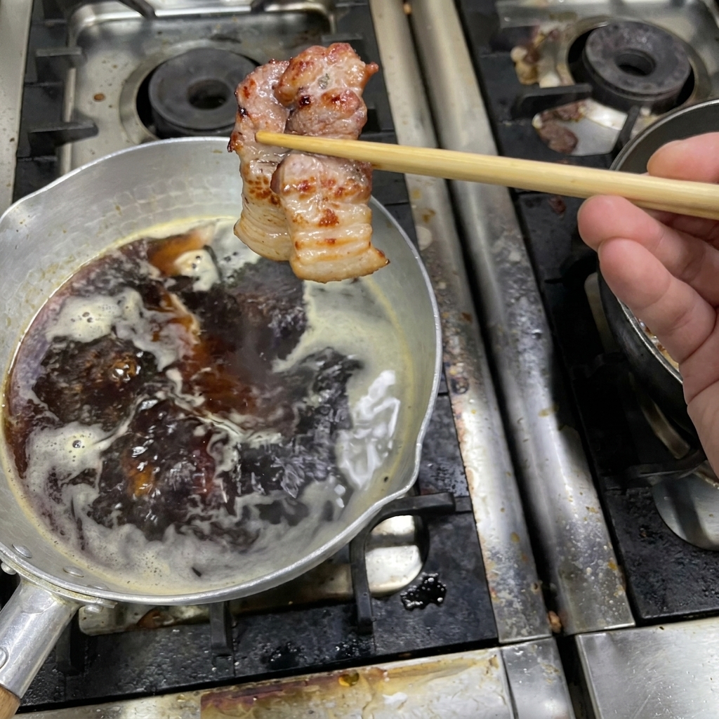 Pancetta rosolata immersa nella salsa scura fumante.