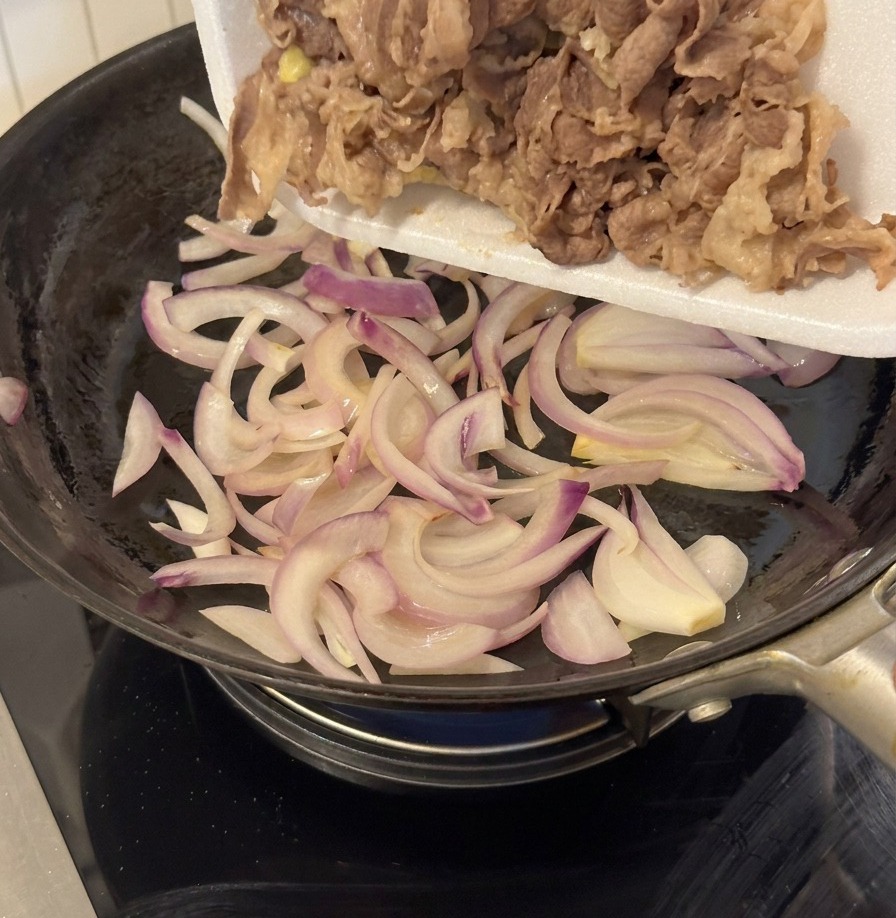 Manzo sbollentato versato in padella con le cipolle saltate.