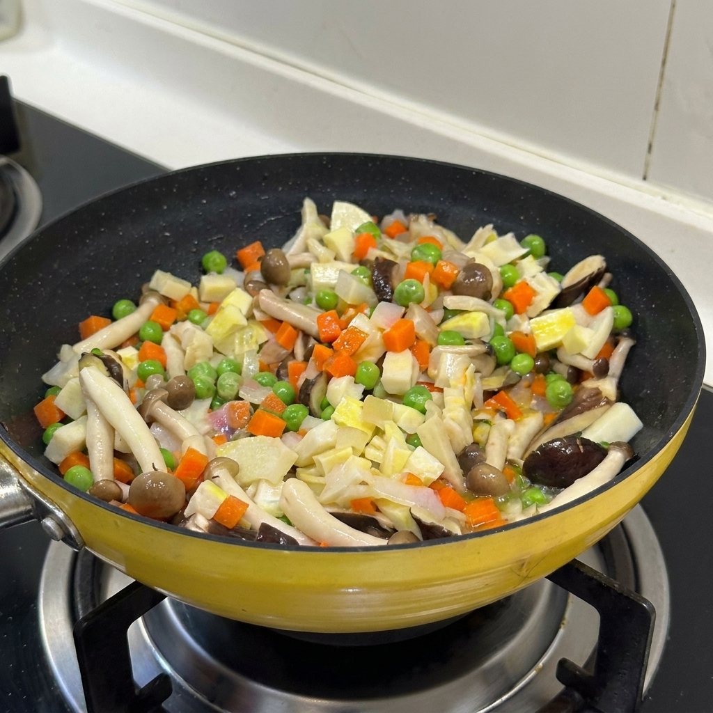 Un mix colorato di verdure e funghi saltati insieme in una padella gialla.