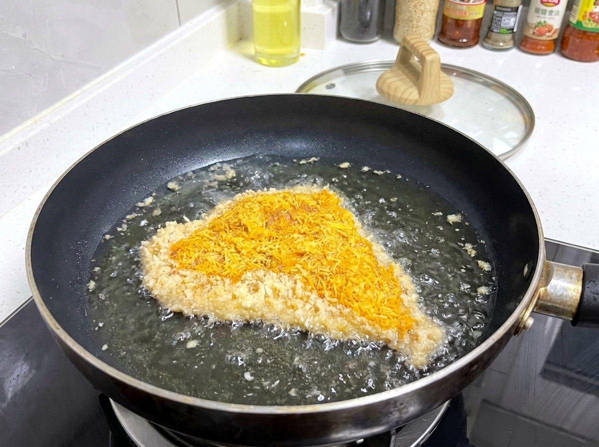 Una cotoletta di maiale impanata che sfrigola in una padella con olio caldo e bollicine sui bordi.