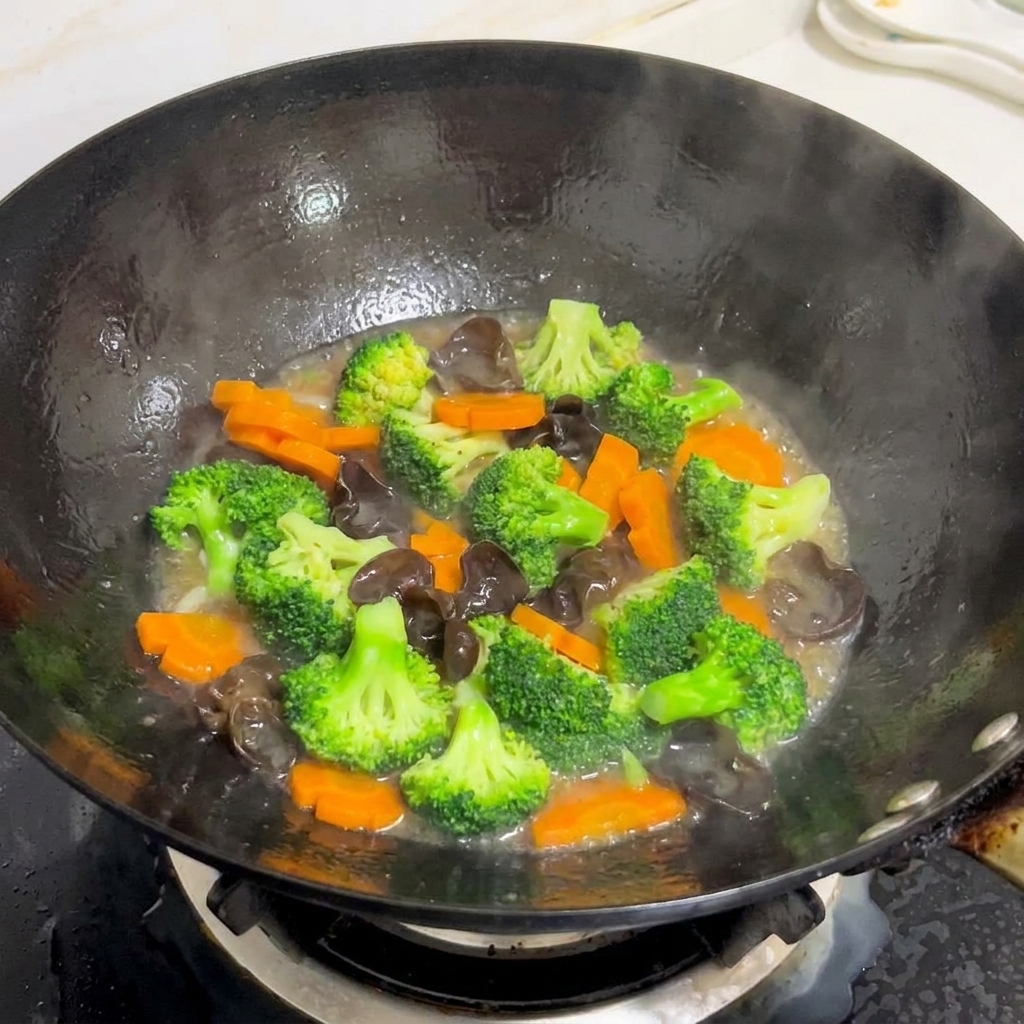 Un mix colorato di broccoli, carote e funghi orecchie dindia saltati in un wok con una salsa lucida.