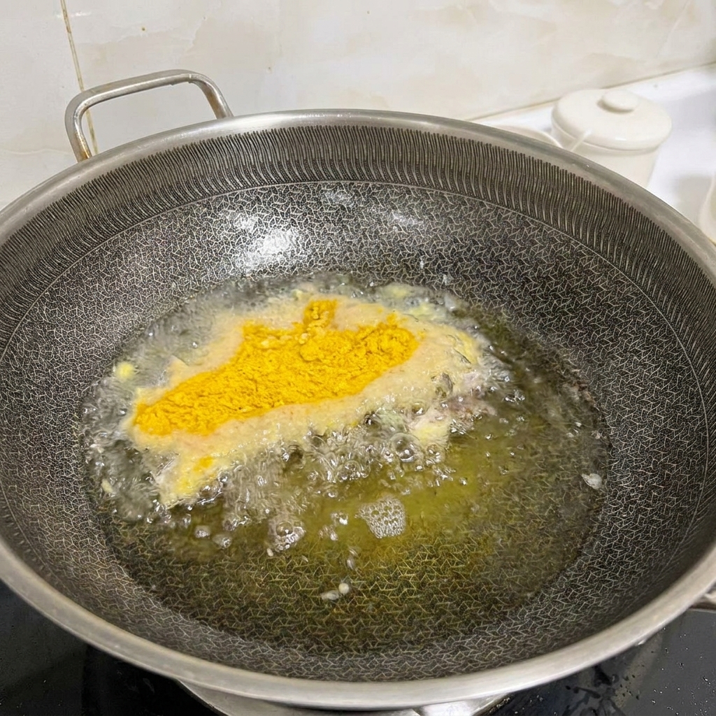 Fette di pollo marinate e impanate che vengono fritte in un wok caldo con olio bollente.