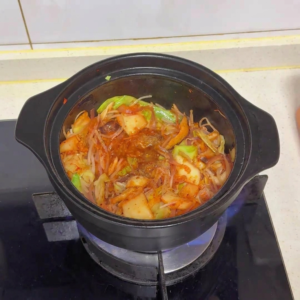 Il mix di verdure e kimchi dopo laggiunta di polvere di brodo e glutammato, con i condimenti che iniziano a legarsi.