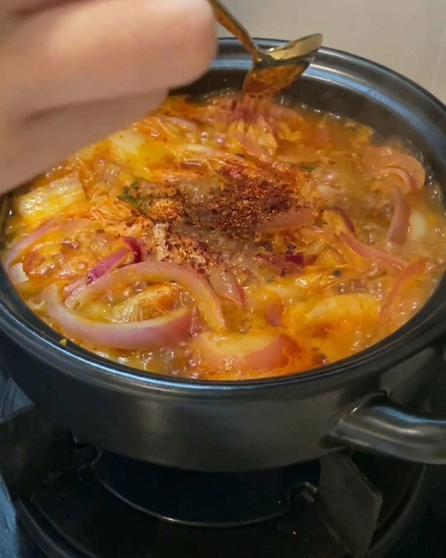 Peperoncino rosso in polvere spolverato sulla superficie della zuppa.