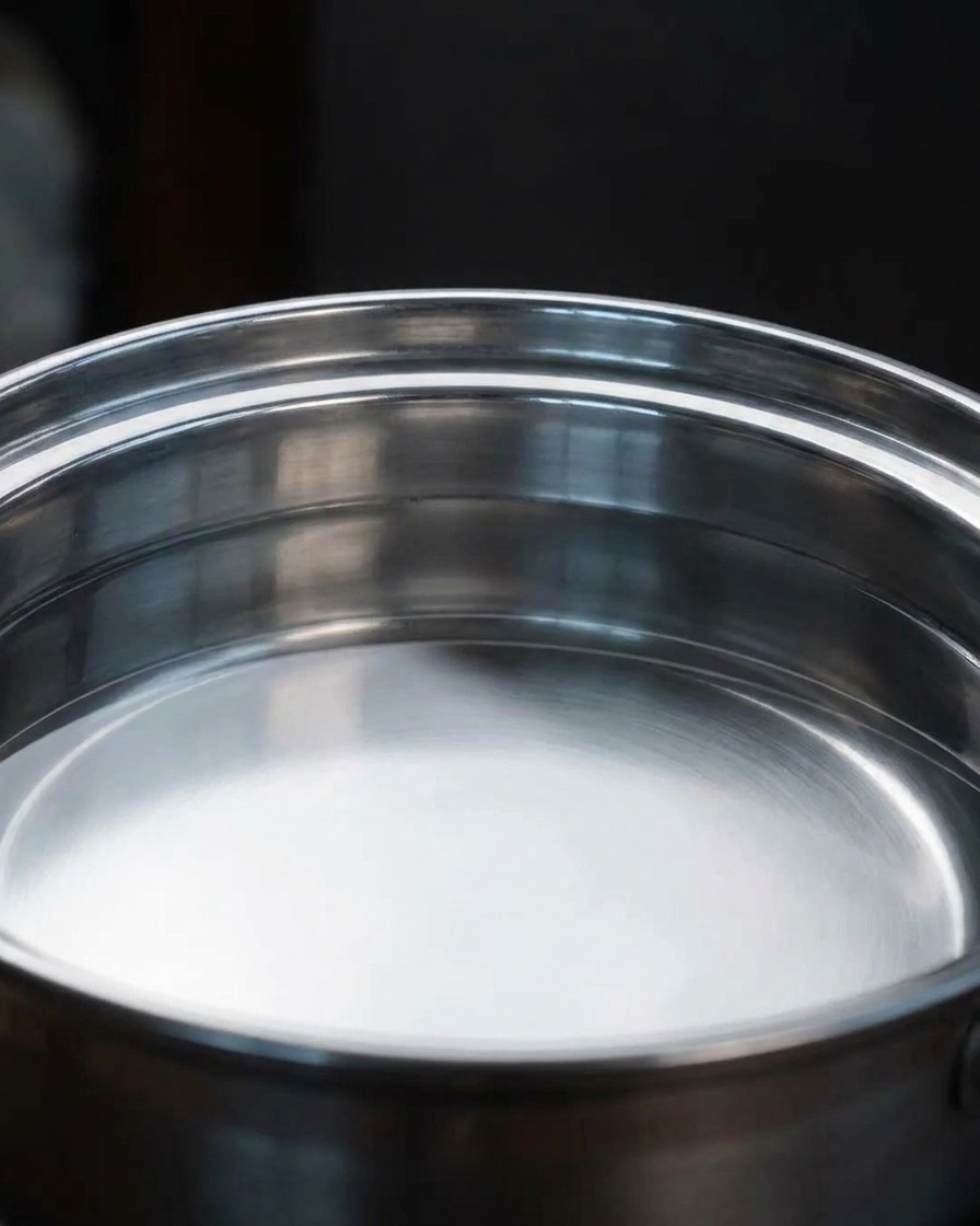 Un grande pezzo di alga verde che sobbolle in una pentola dacqua con vapore che sale.