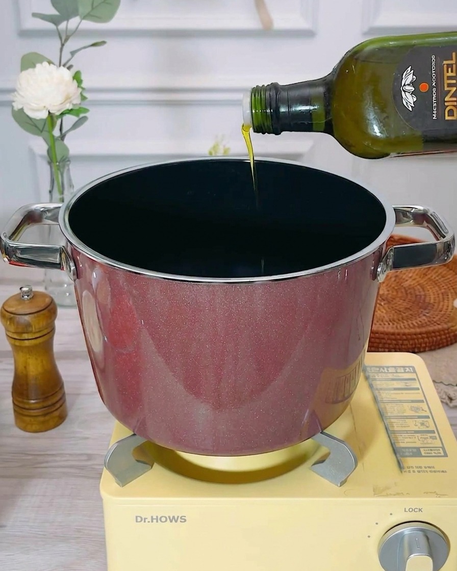 Olio extravergine doliva versato in una pentola vuota e preriscaldata.