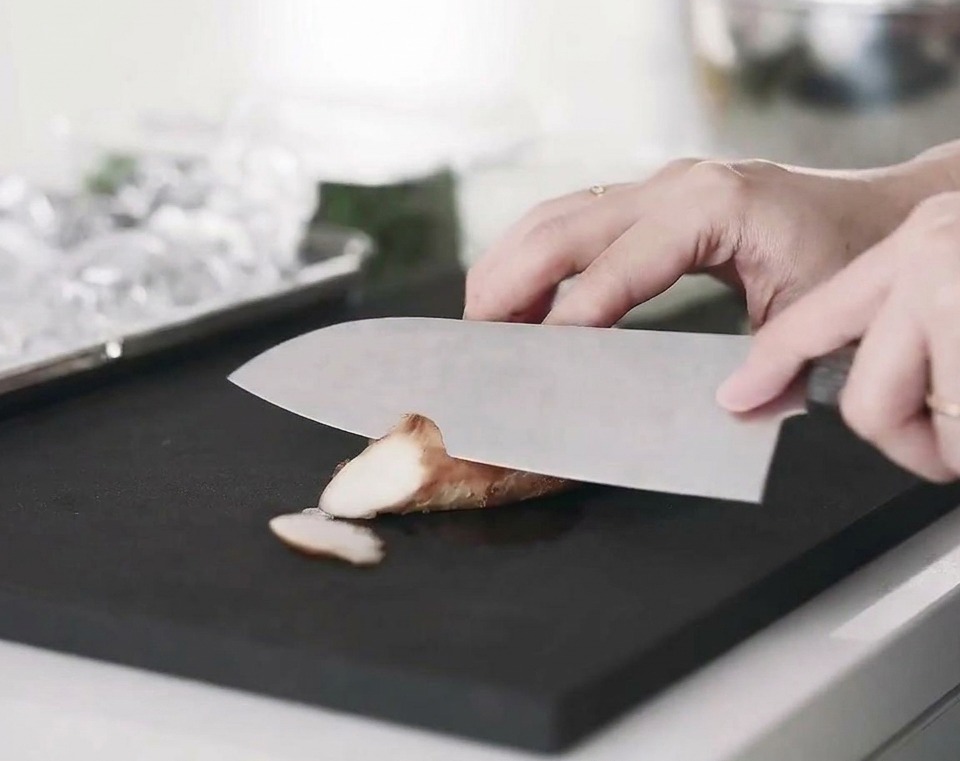 Fettine di petto di pollo cotto disposte su un tagliere.