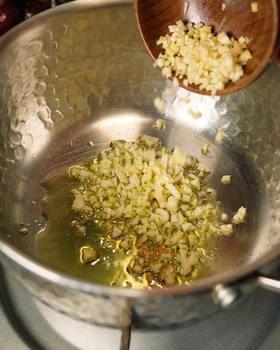 Cipolle e aglio che soffriggono in olio doliva in una pentola.