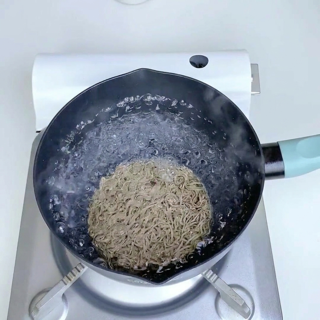 Noodles di grano saraceno in cottura in acqua bollente.