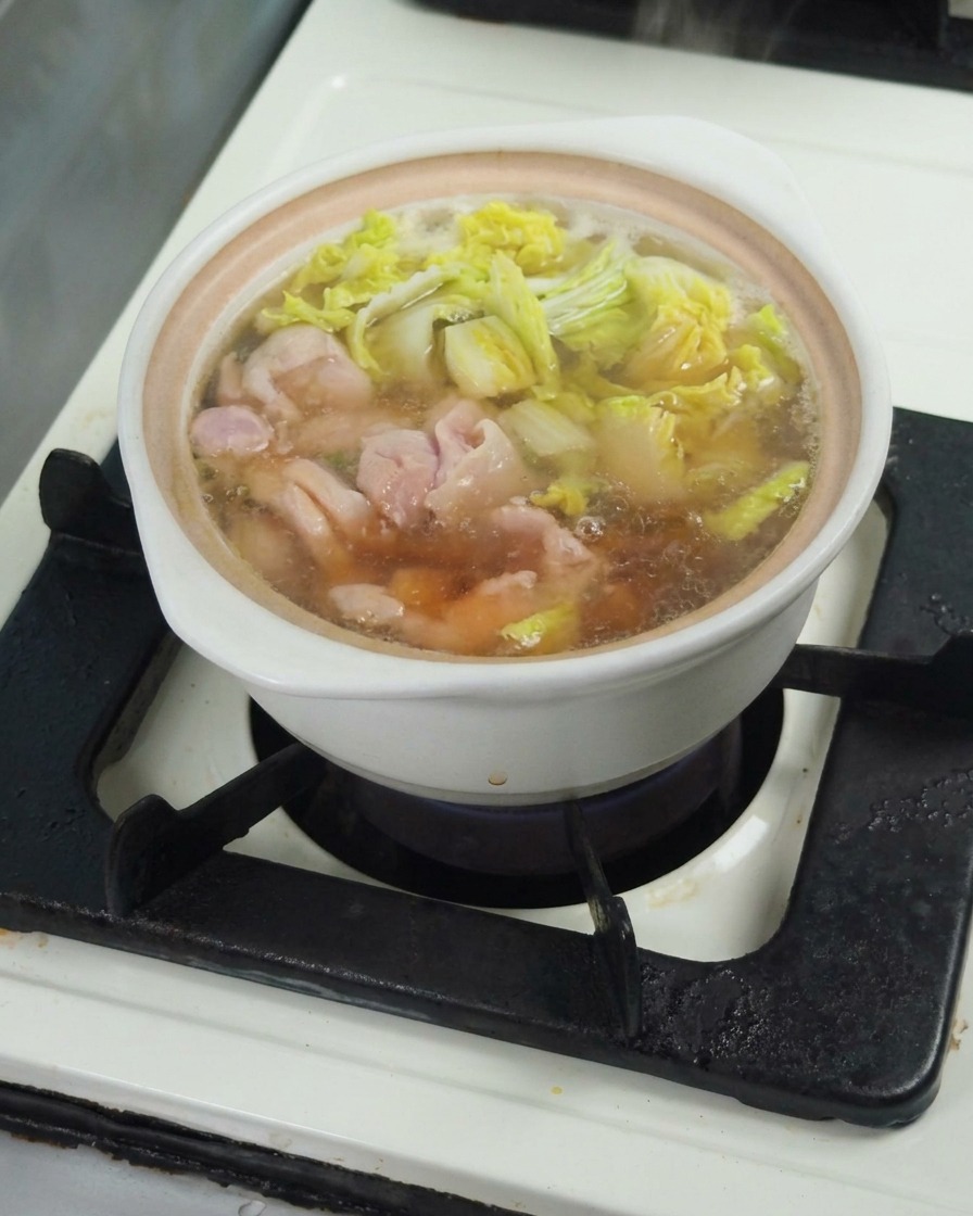 Salsa di soia versata nel brodo che sobbolle per insaporire il piatto.