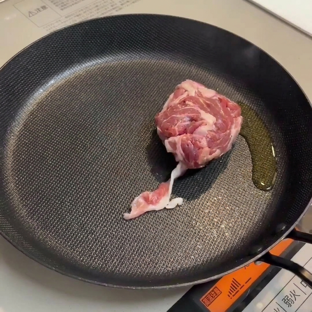 Maiale e salsicce che rosolano in padella per creare una base saporita.