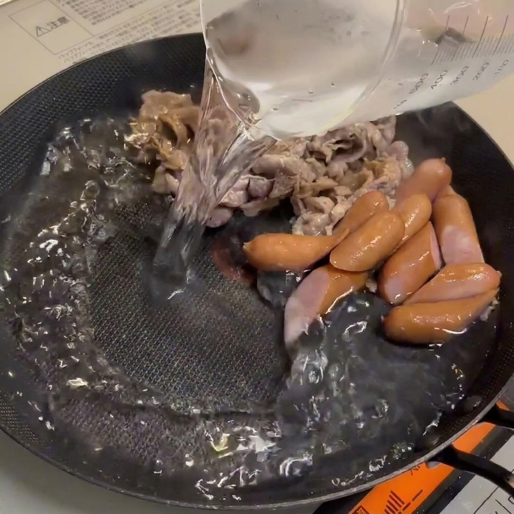 Acqua aggiunta alla padella, creando una base per il brodo ricco.