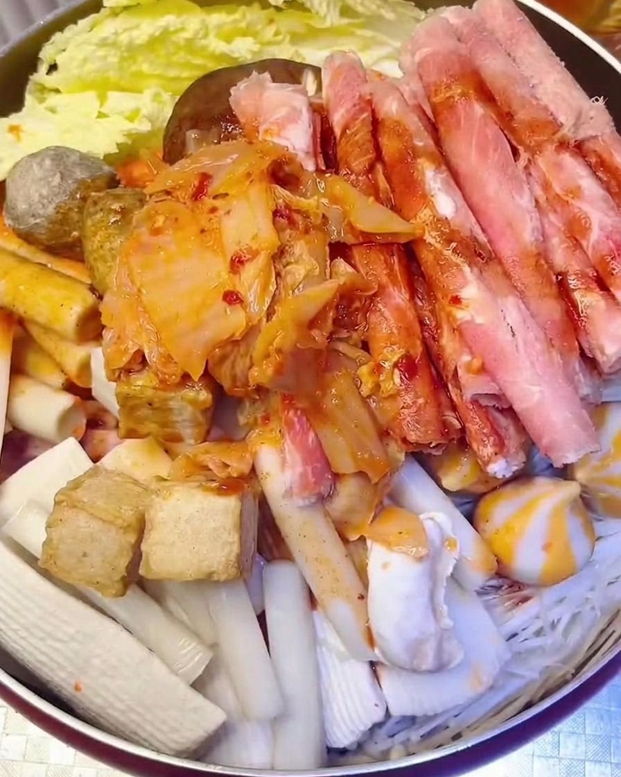 Kimchi rosso tritato aggiunto alla pentola con acqua versata sopra.