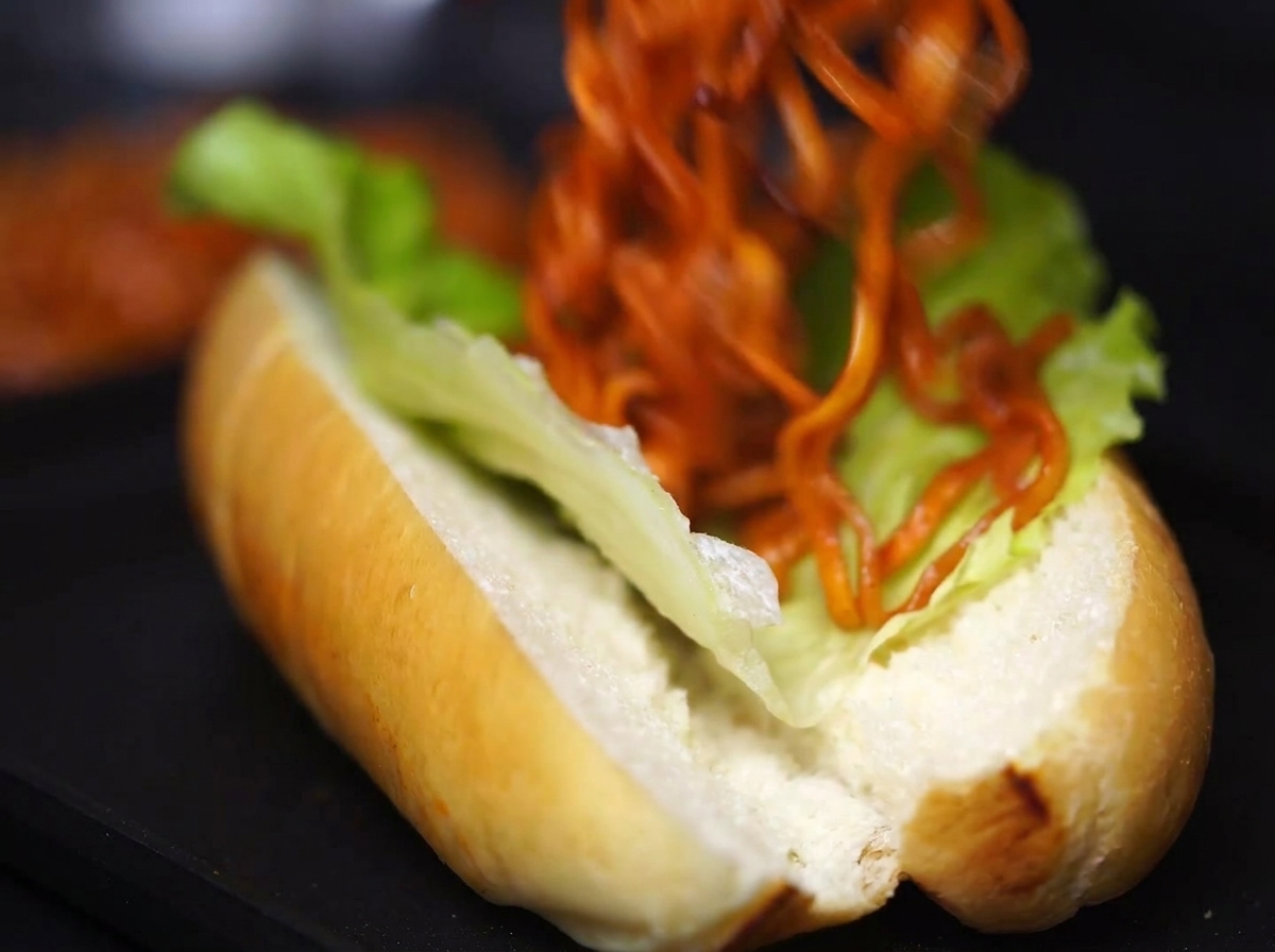 Una porzione generosa di noodles conditi inseriti nel panino con lattuga.