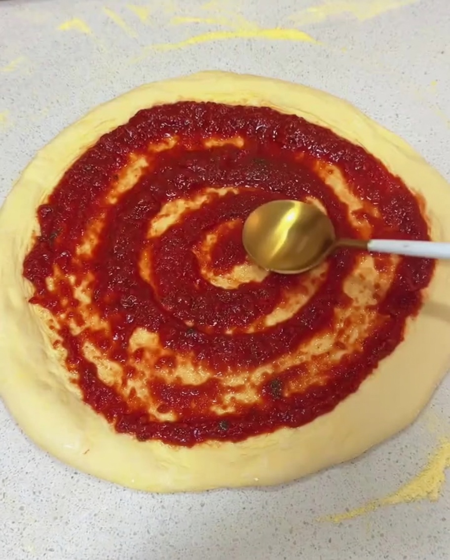 Stesura della salsa di pomodoro con il dorso di un cucchiaio.