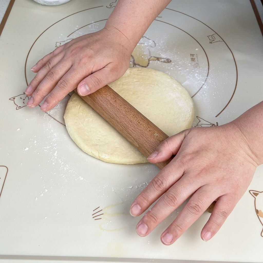 Mattarello che stende limpasto in un quadrato su un tappetino.