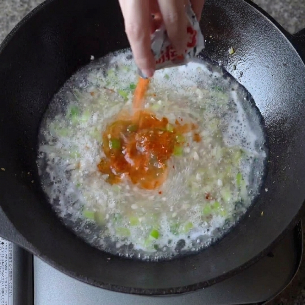 Condimento in polvere per ramen spolverato nel brodo bollente.