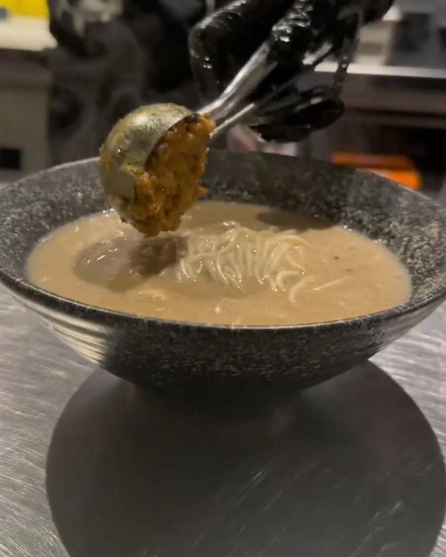 Un cucchiaio di carne macinata condita aggiunto con cura sopra il ramen.