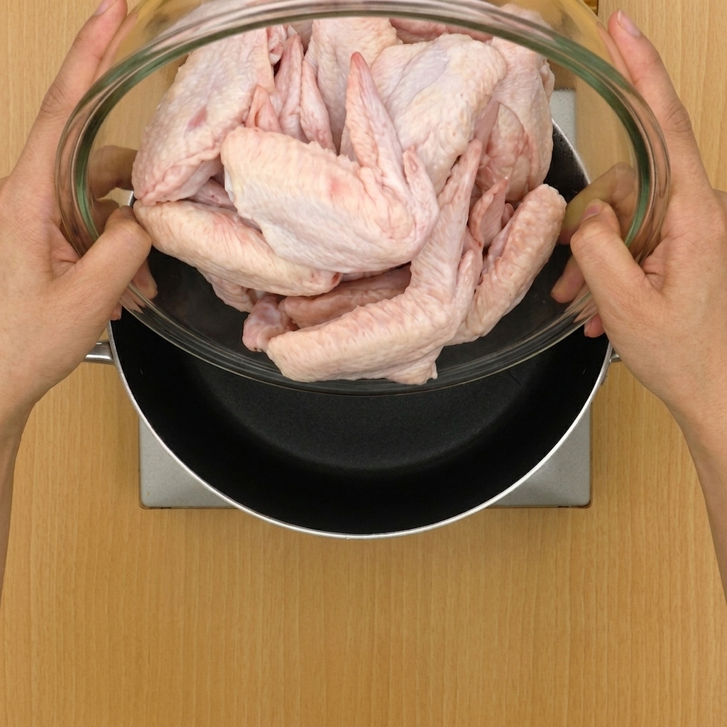 Alette di pollo e aromi aggiunti in una grande pentola piena dacqua.