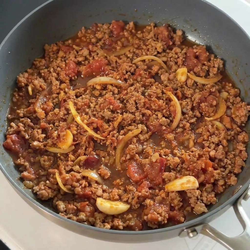 Salsa di soia versata sulla carne condita in padella.