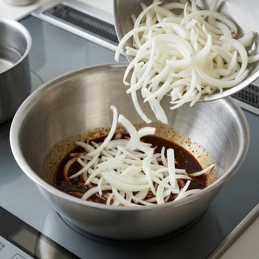Noodles cotti mescolati con la salsa al sesamo in una ciotola capiente.