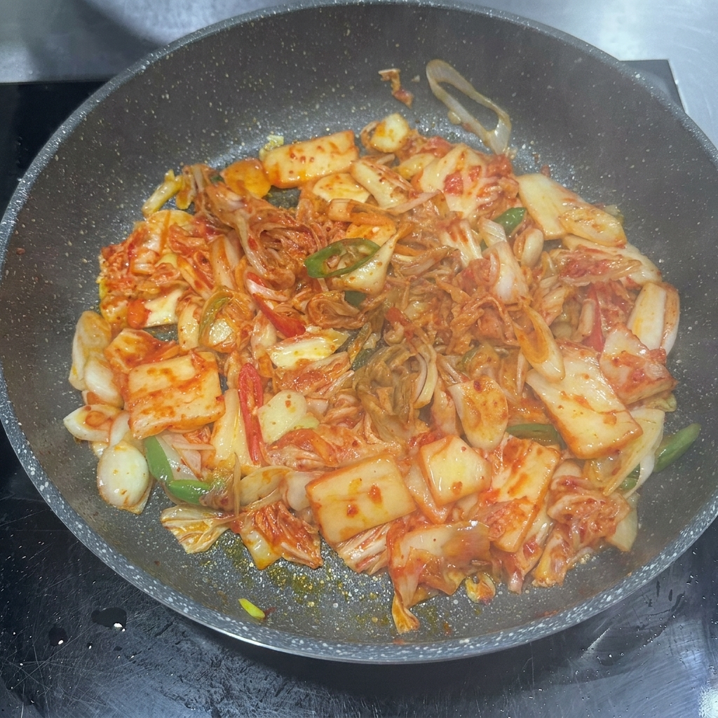 Pasta di peperoncino, salsa di soia e zucchero aggiunti in padella con il kimchi.
