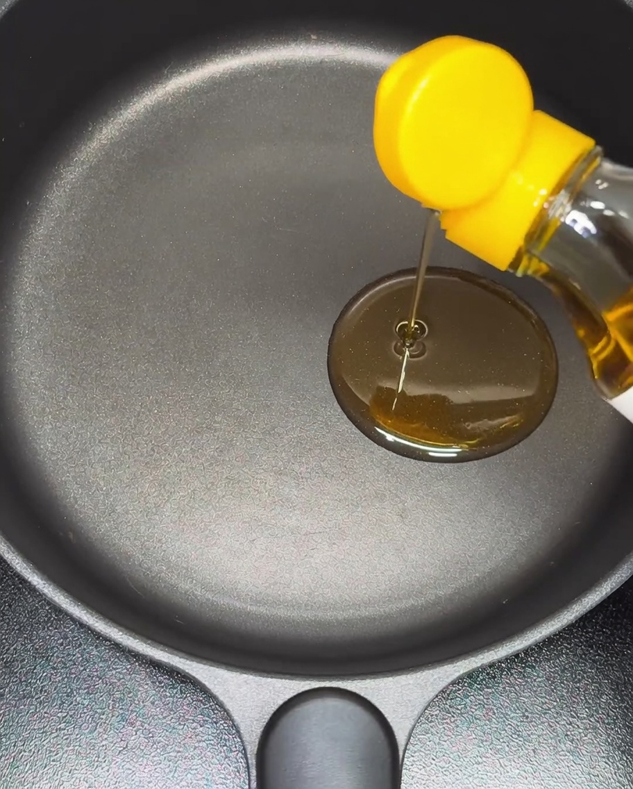 Olio di sesamo versato in una padella antiaderente.