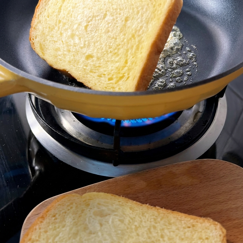 Fette di pane tostato dorate in una padella gialla con burro fuso.
