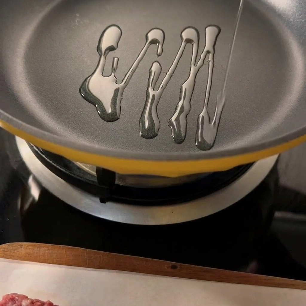 Due hamburger di manzo conditi che scottano in una padella calda con olio visibile.