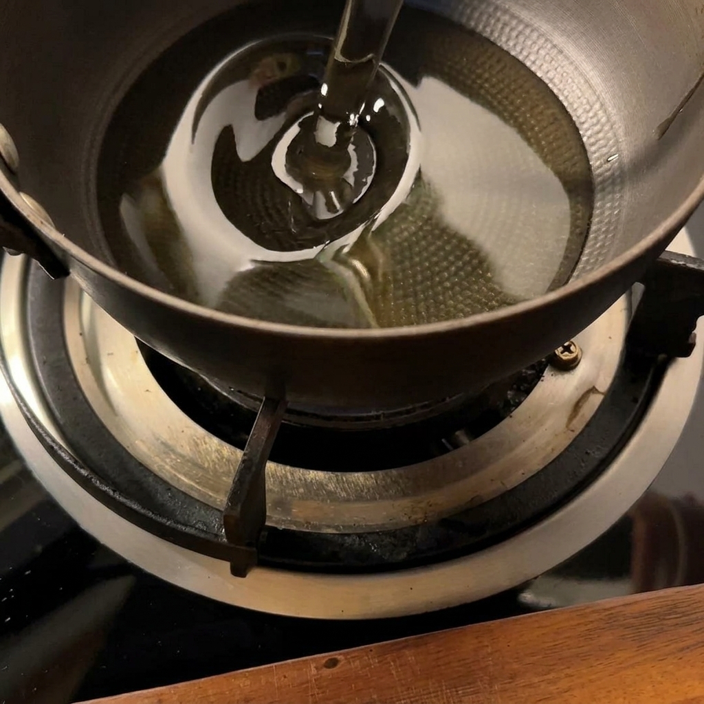 Patate che friggono in una piccola pentola di olio bollente fino a diventare dorate.