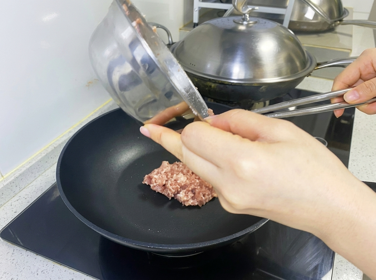 Composto di carne cruda posizionato in una padella nera per formare lhamburger.