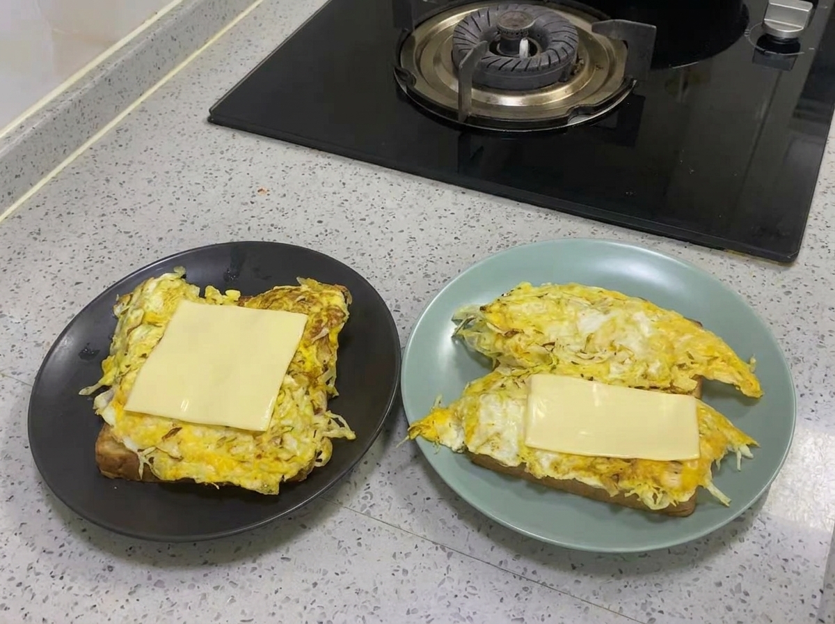 Una fetta di formaggio giallo che fonde sopra lo strato cotto di uovo e cavolo.