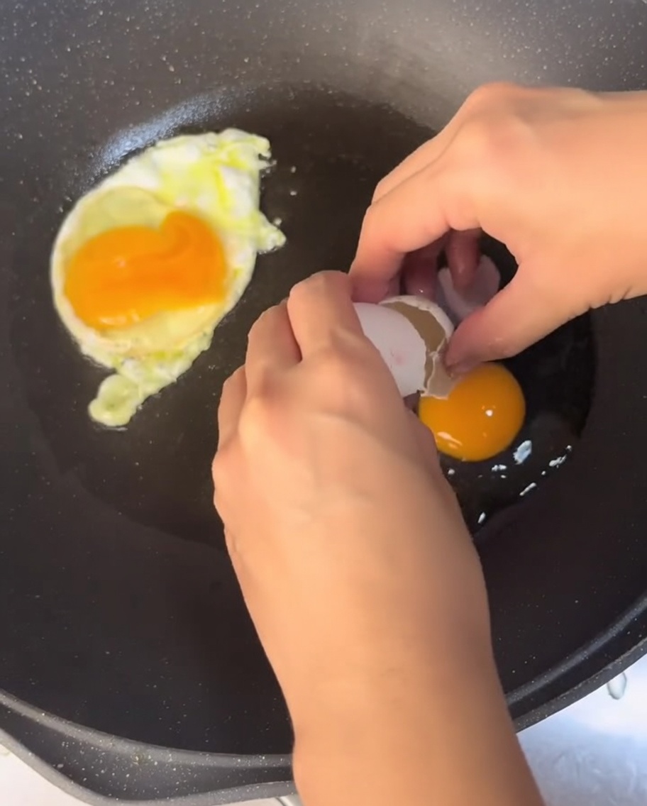 Uova che friggono in una padella con olio caldo.