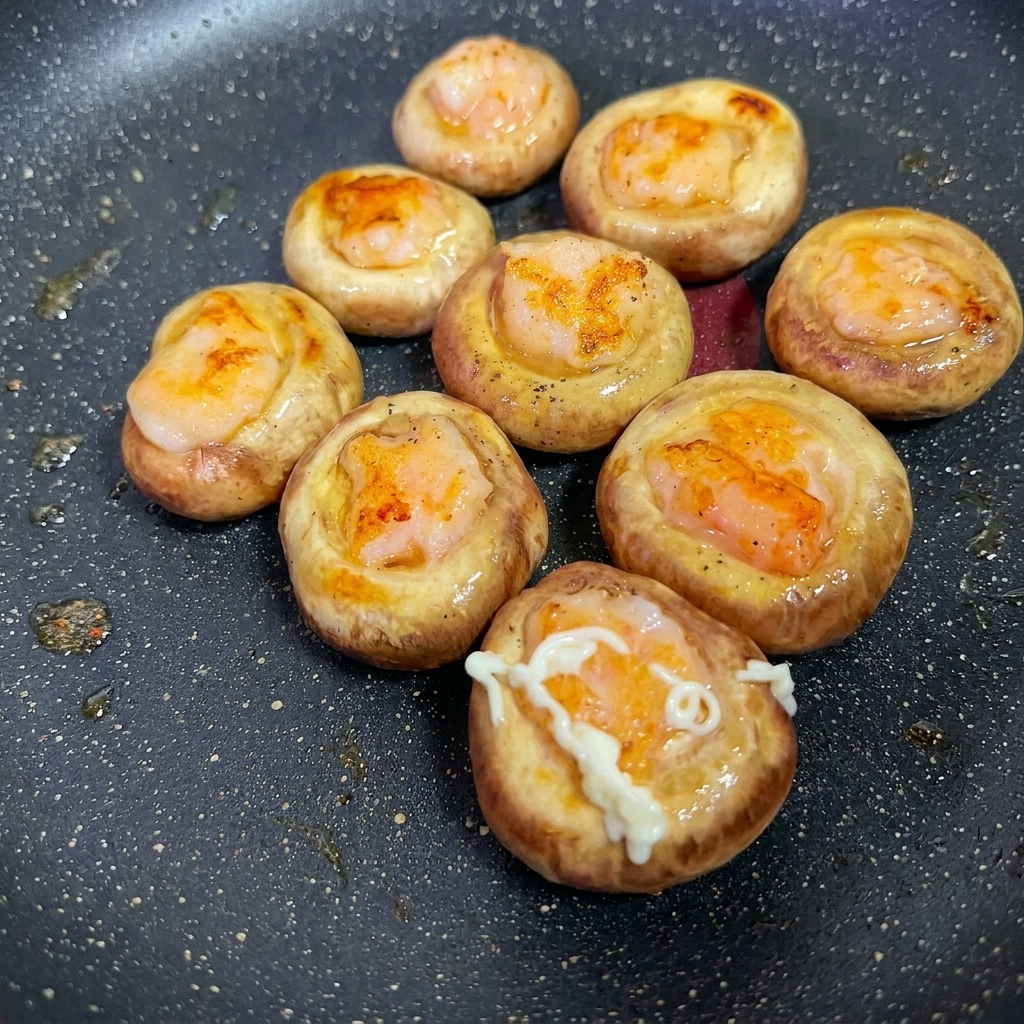 Dettaglio del condimento applicato sulla superficie dei funghi ripieni.