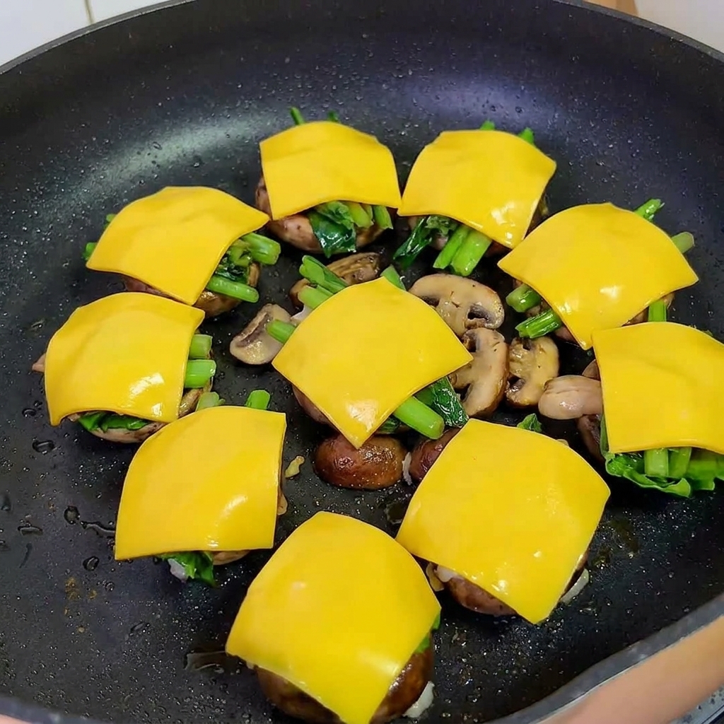 Padella coperta con un coperchio per sciogliere il formaggio sui mini burger.