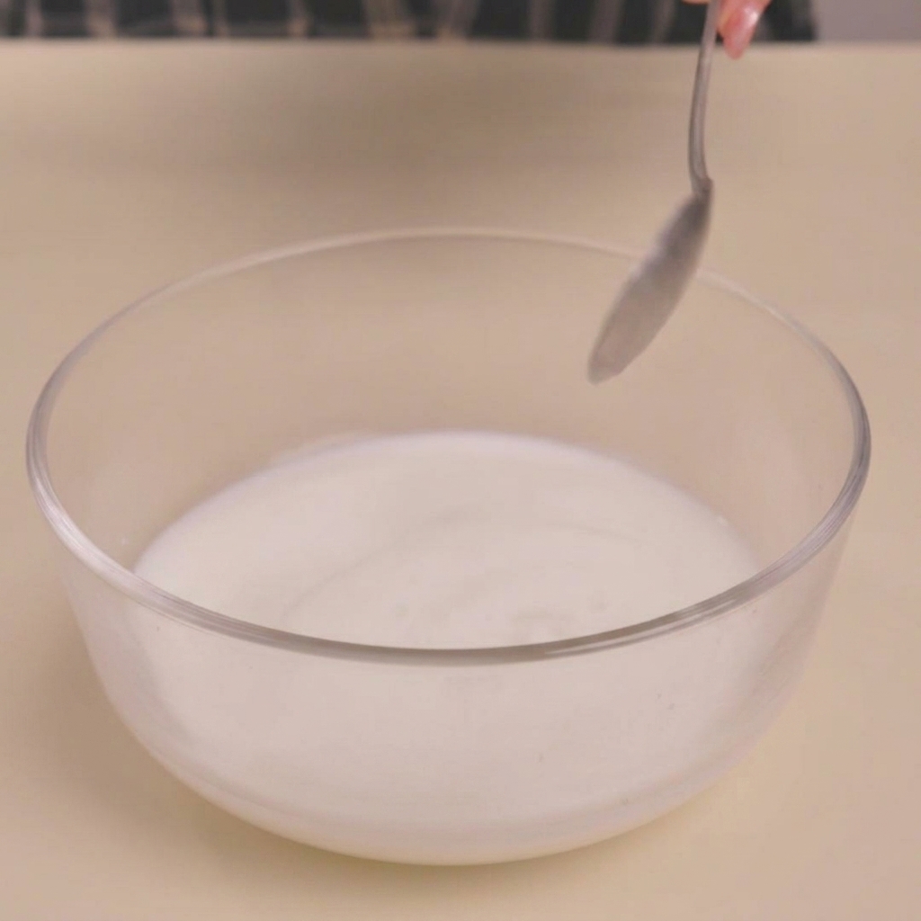 Latte che si caglia in una ciotola dopo laggiunta di aceto, creando una consistenza simile al latticello.