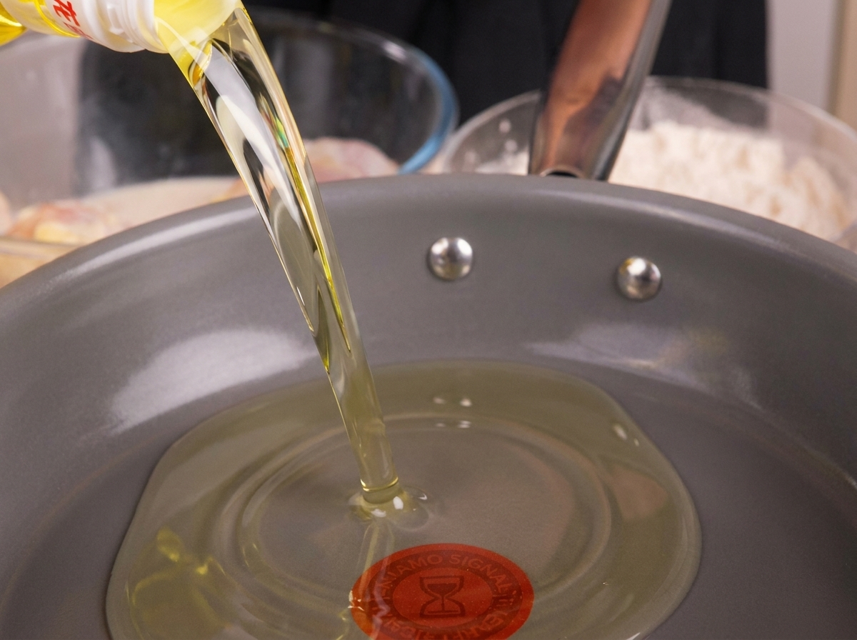 Olio per friggere versato in una padella, pronto per essere riscaldato.