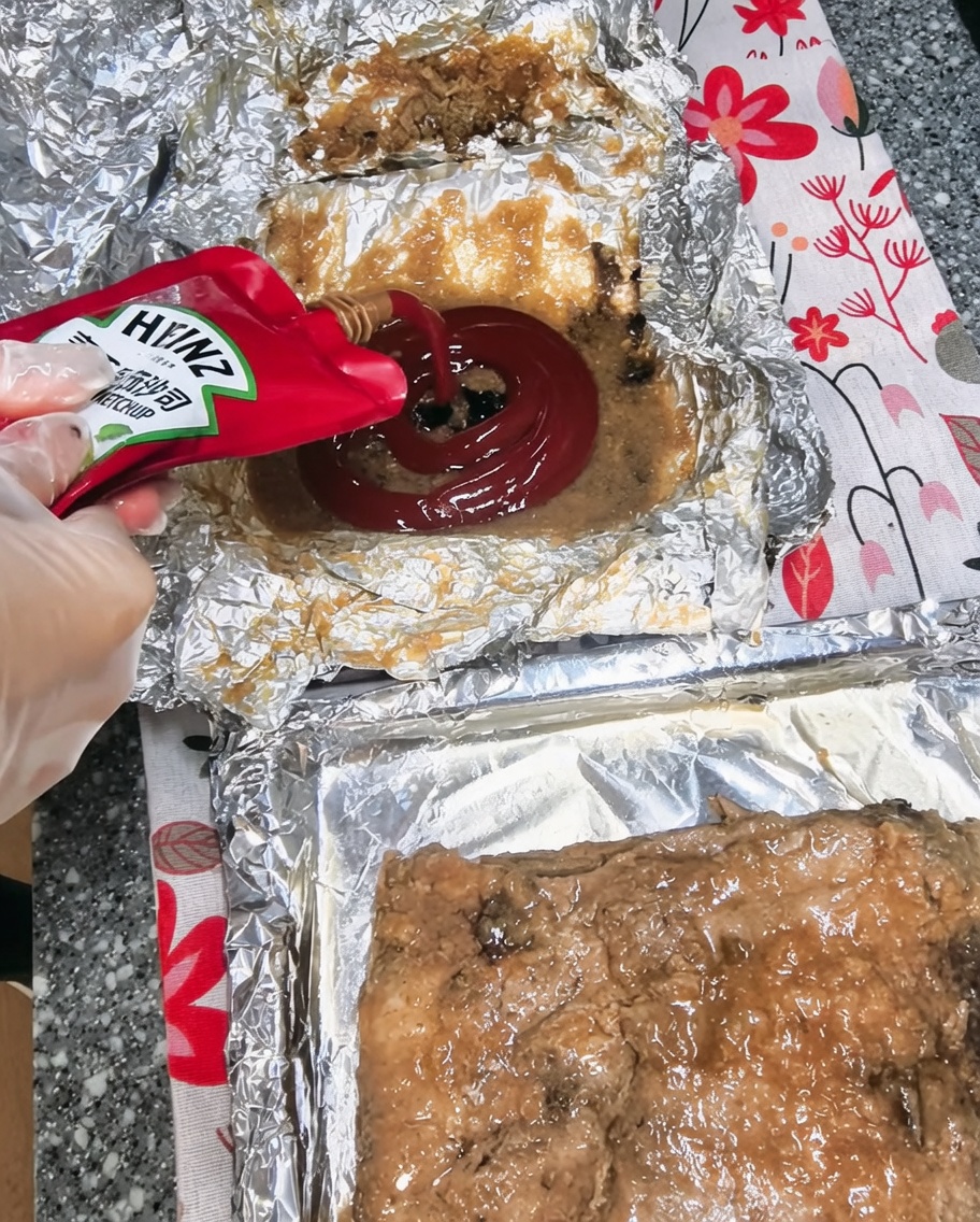 Ketchup aggiunto in una ciotola con i succhi di cottura e altri ingredienti.