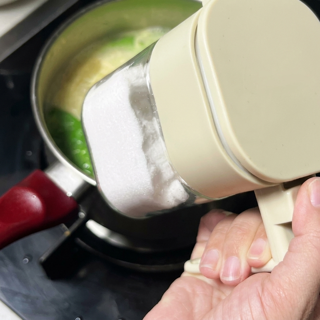 Sale aggiunto alla zuppa da un contenitore trasparente per condimenti.
