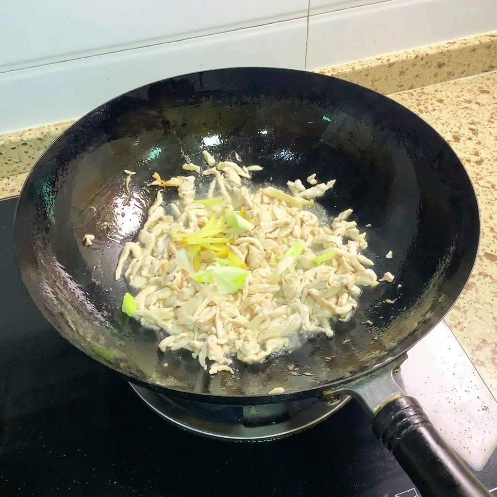 Cipollotti e zenzero soffritti insieme al pollo nel wok.